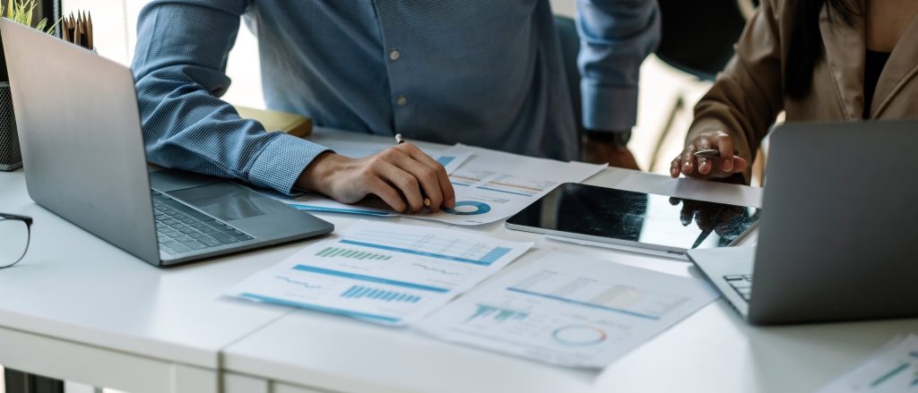 businessman and partnership pointing the graph to analyze the marketing plan with calculater and