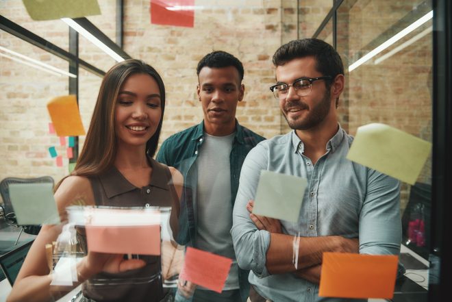Fresh ideas. Cheerful male and female colleagues planning working process and using colorful