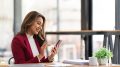 Smiling beautiful Asian businesswoman analyzing chart and graph showing changes on the market and