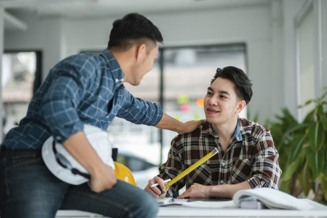 Two Male Engineer collaboration in Modern Office Environment with Blueprints and Measuring Tools