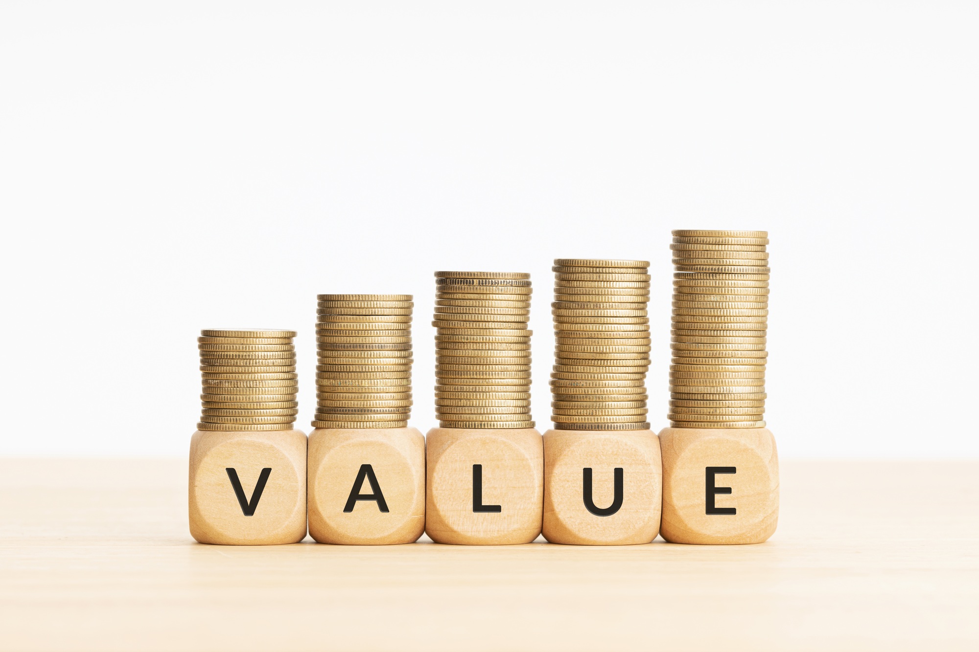 Value word on wooden blocks and rising stacked coins